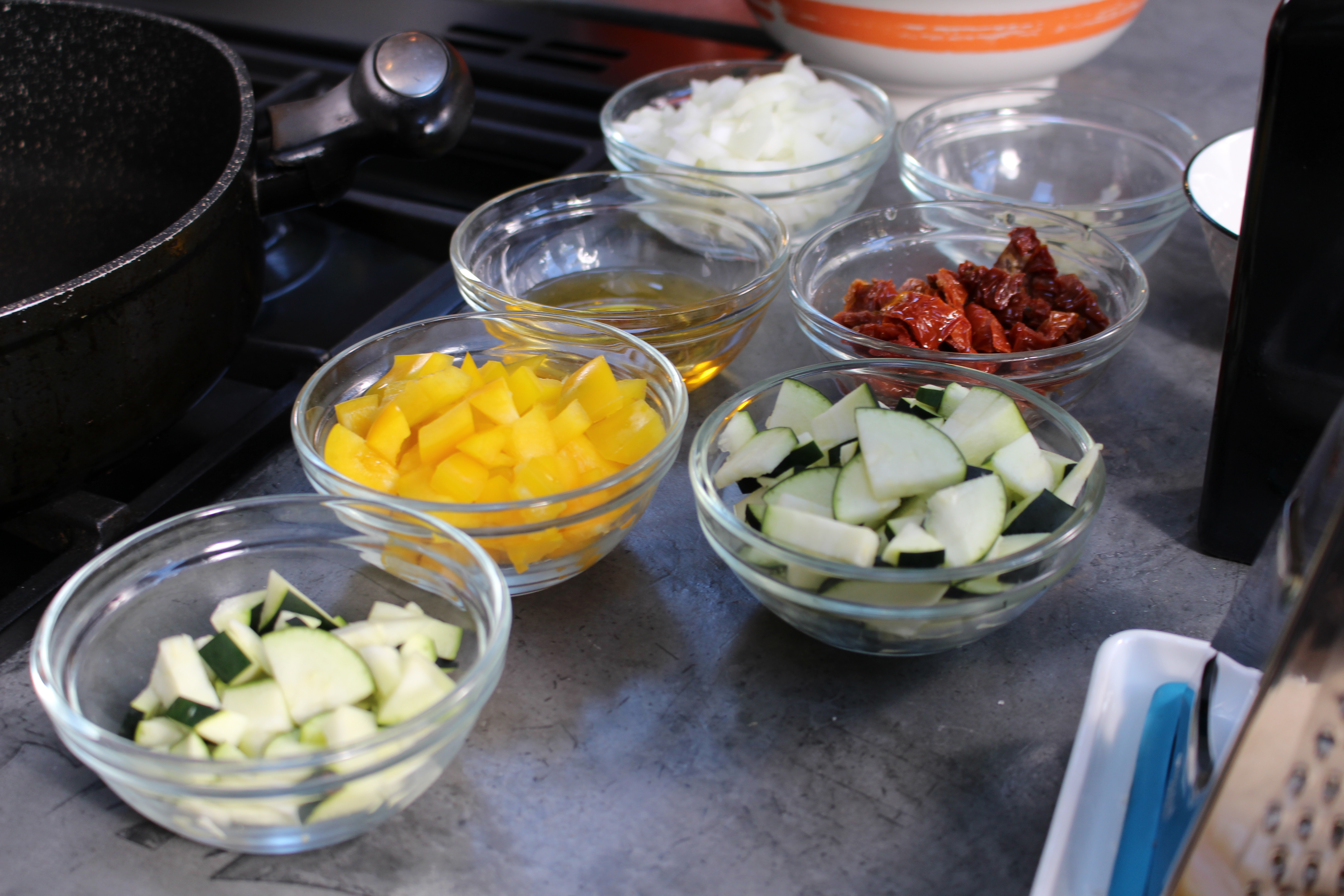 Photo of chopped onion, sundried tomatoes, courgette, peppers and oil