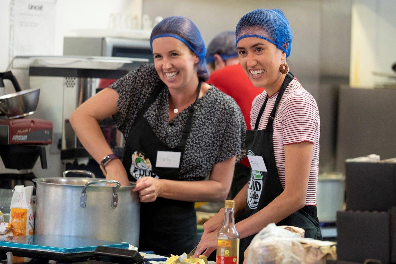 Foodcycle Peckham team smiling with hairnets in the kitchen