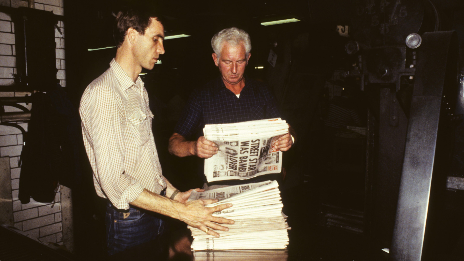 newspaper employees picking up newspapers