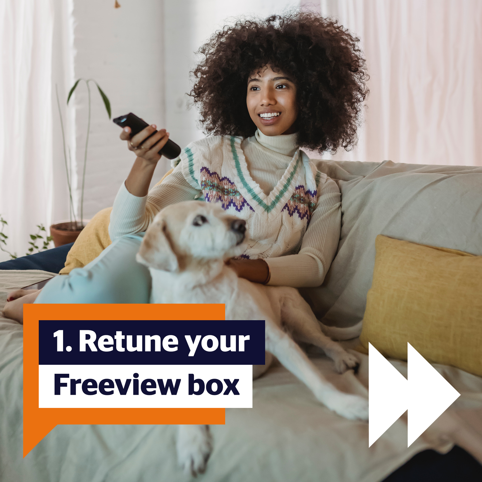 Step 1: Retune your Freeview Box. Image of woman with afro smiling holding a remote control and petting a white Labrador on a sofa.