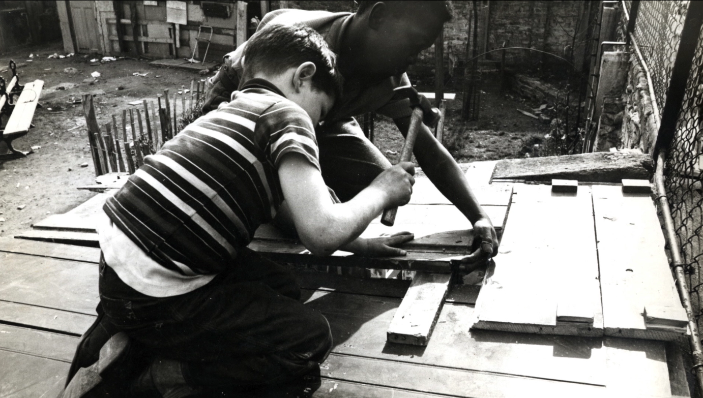 Child helping man build